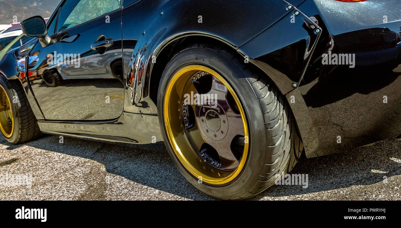 Black car with gold wheel rim and black spokes Stock Photo - Alamy
