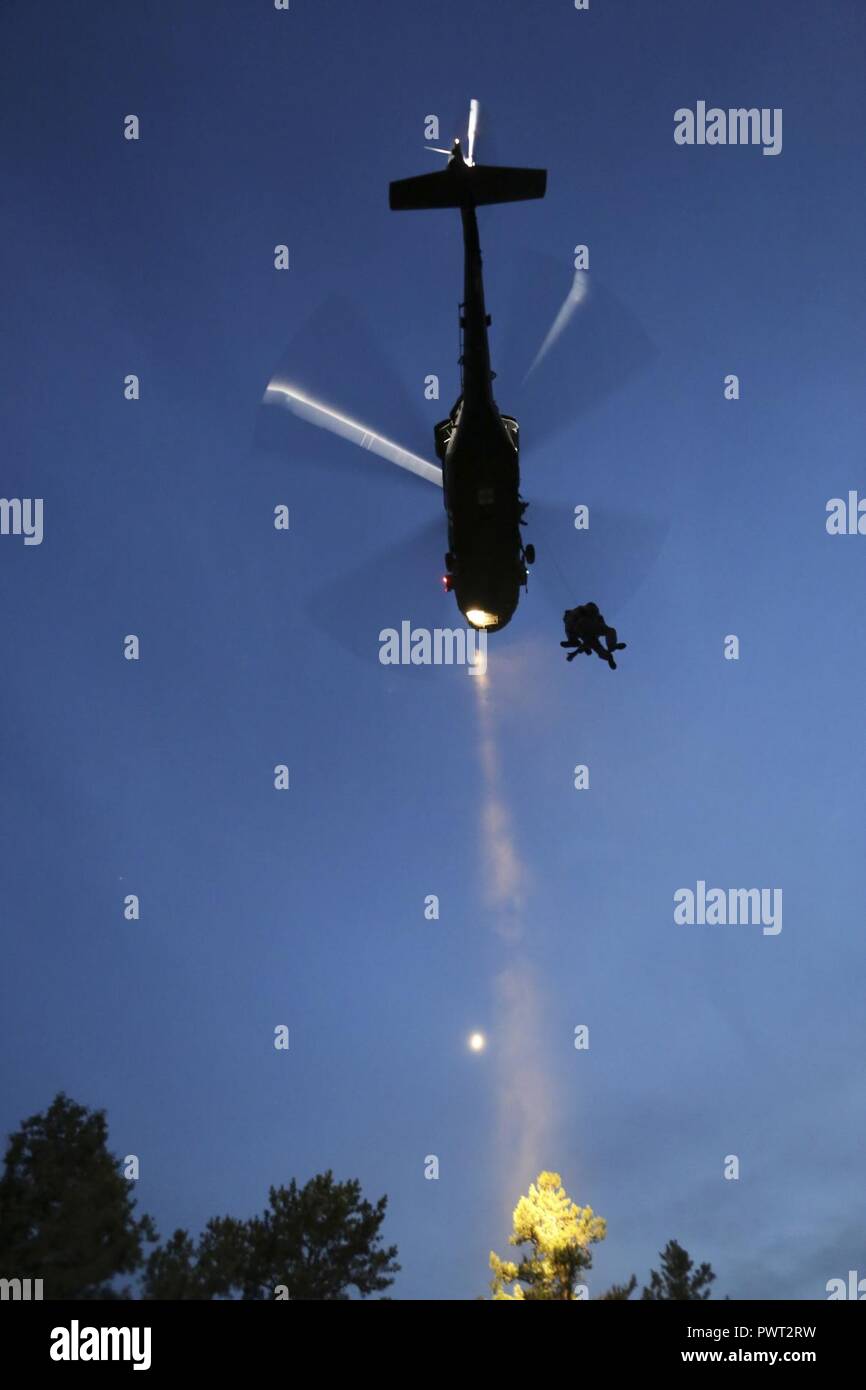 U.S. Air Force tactical control party airmen from the 227th Air Support Operations Squadron descend from a 1-150th Assault Helicopter Battalion UH-60 Black Hawk helicopter during joint training for New Jersey Task Force One at Joint Base McGuire-Dix-Lakehurst, N.J., June 28, 2017. The primary mission of New Jersey Task Force One is to provide advanced technical search and rescue capabilities to victims trapped or entombed in structurally collapsed buildings. Task Force One is made up of New Jersey National Guard Soldiers and Airmen, as well as civilians. Stock Photo