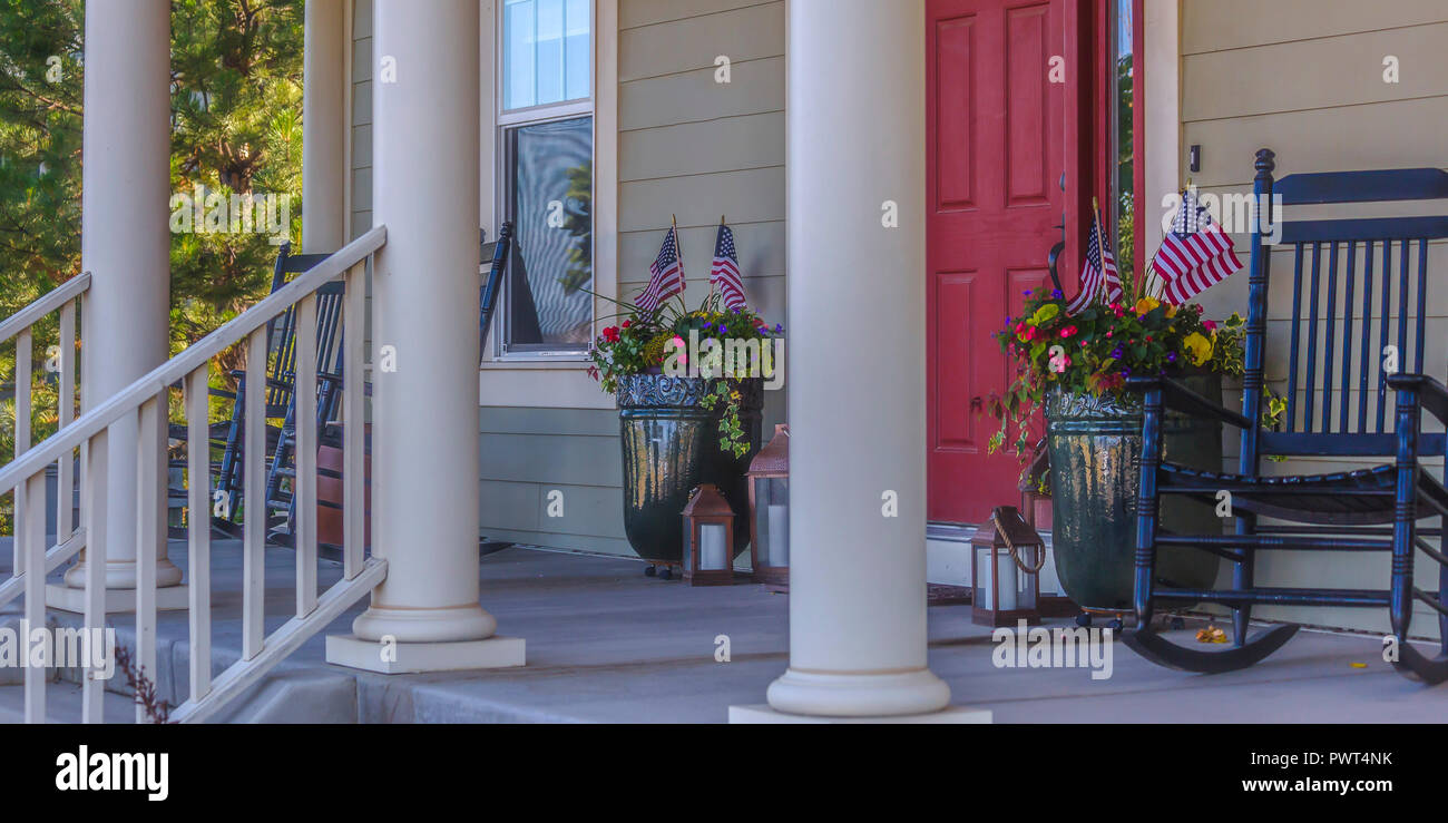 Front porch with stairs red door and rocking chair Stock Photo