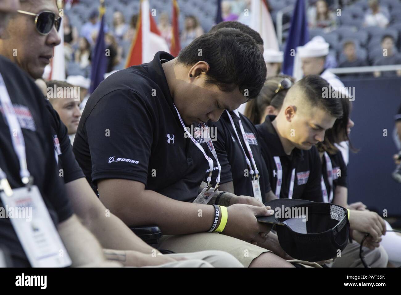 U.S. Army veteran Jarred Vaina listens to the invocation during the opening ceremony for the 2017 Department of Defense Warrior Games at Chicago, Ill., July 1, 2017. The DOD Warrior Games are an annual event allowing wounded, ill and injured service members and veterans in Paralympic-style sports including archery, cycling, field, shooting, sitting volleyball, swimming, track and wheelchair basketball. Stock Photo