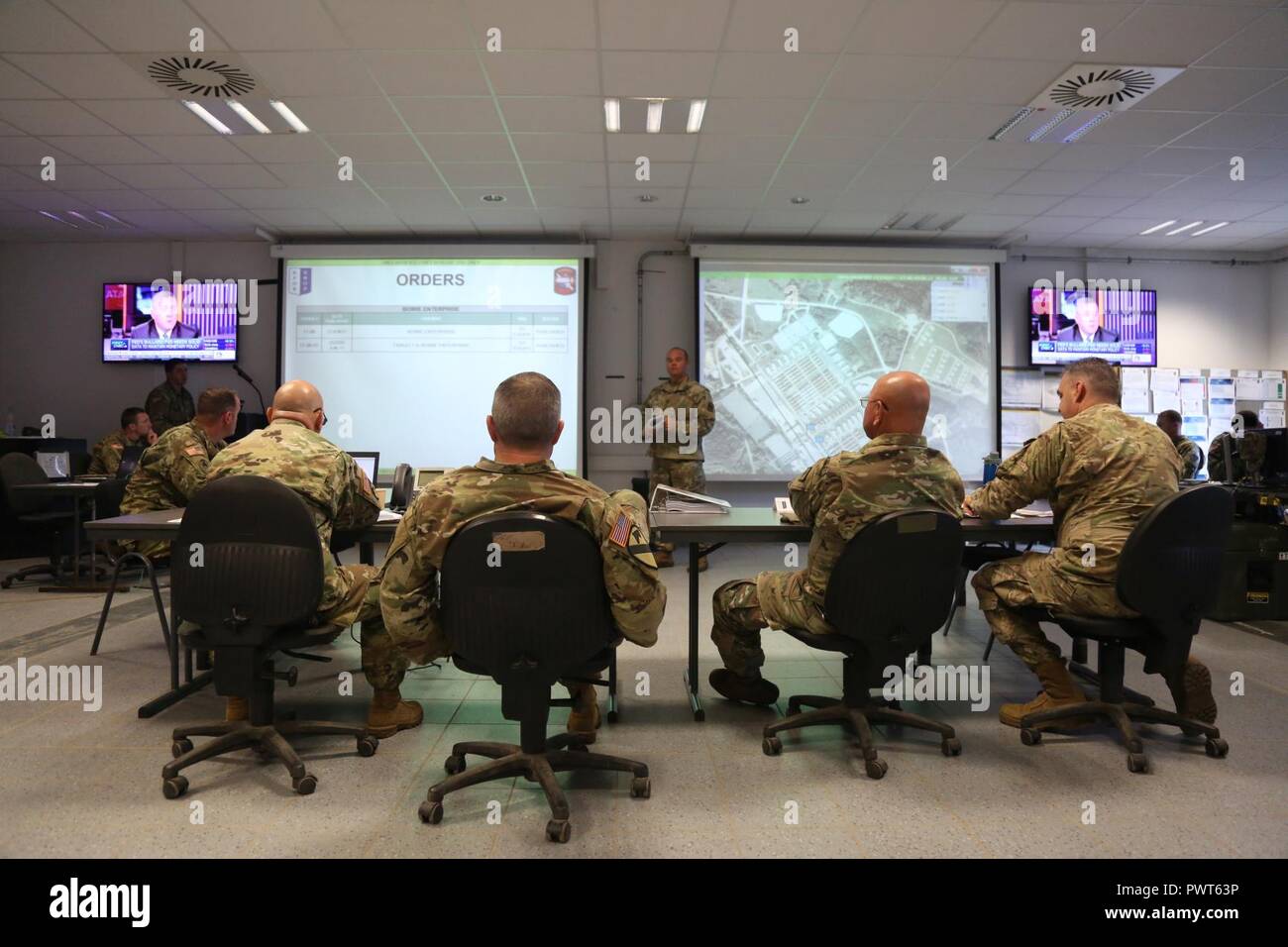 U.S. Soldiers of 39th Infantry Brigade, 35th Infantry Division conduct a mission brief while managing a tactical operations center during a Kosovo Force (KFOR) mission rehearsal exercise (MRE) at the Joint Multinational Readiness Center in Hohenfels, Germany, June 30, 2017. The KFOR MRE 23 is designed to prepare the 39th Infantry Brigade Combat Team for their deployment to Kosovo in support of civil authorities to maintain a safe and secure environment. KFOR MRE 23 hosts 900 soldiers from 10 nations. The exercise runs from June 19 through July 11 in Hohenfels, Germany. Stock Photo