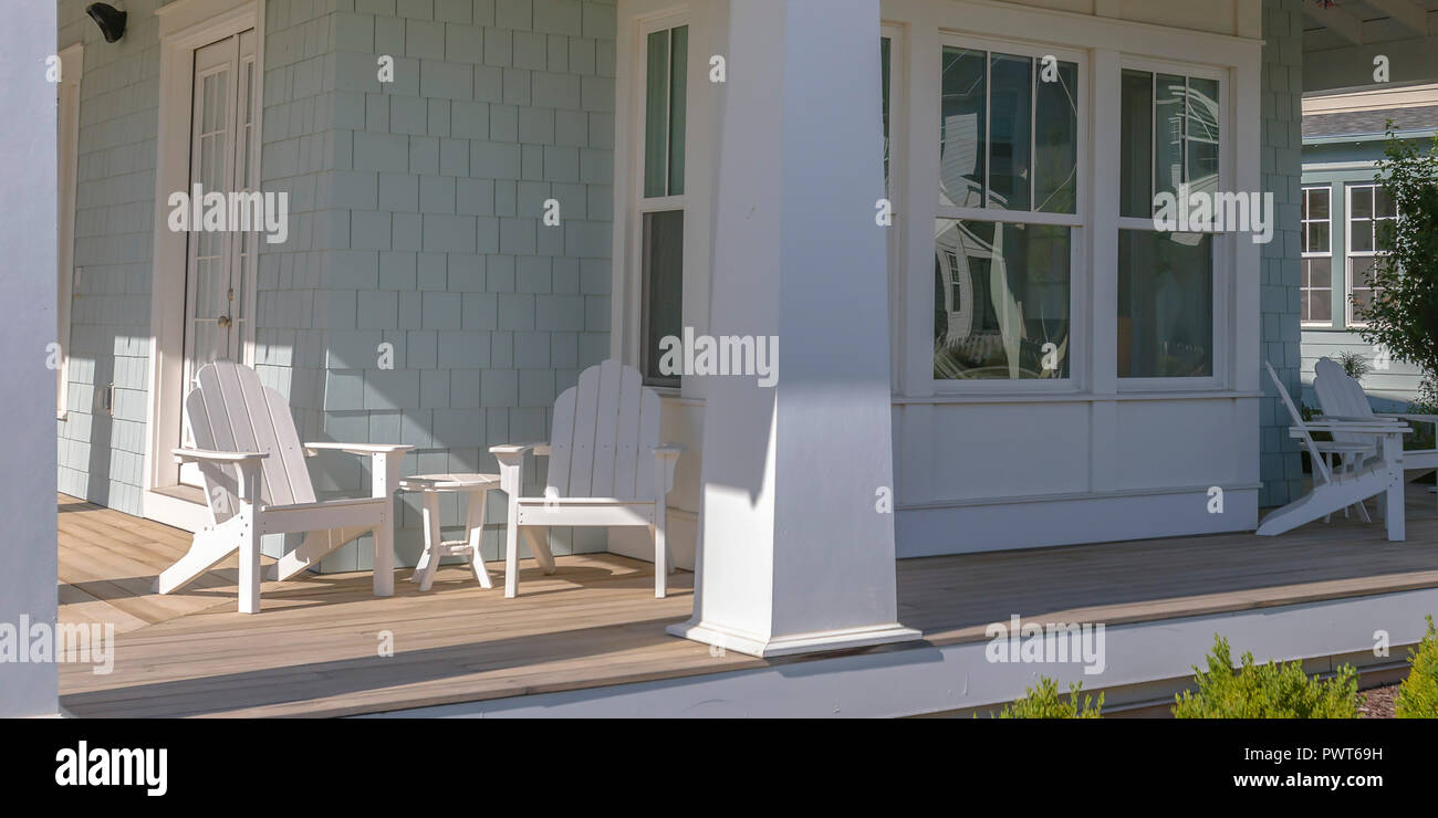Home with tables and chairs on the sunlit porch Stock Photo
