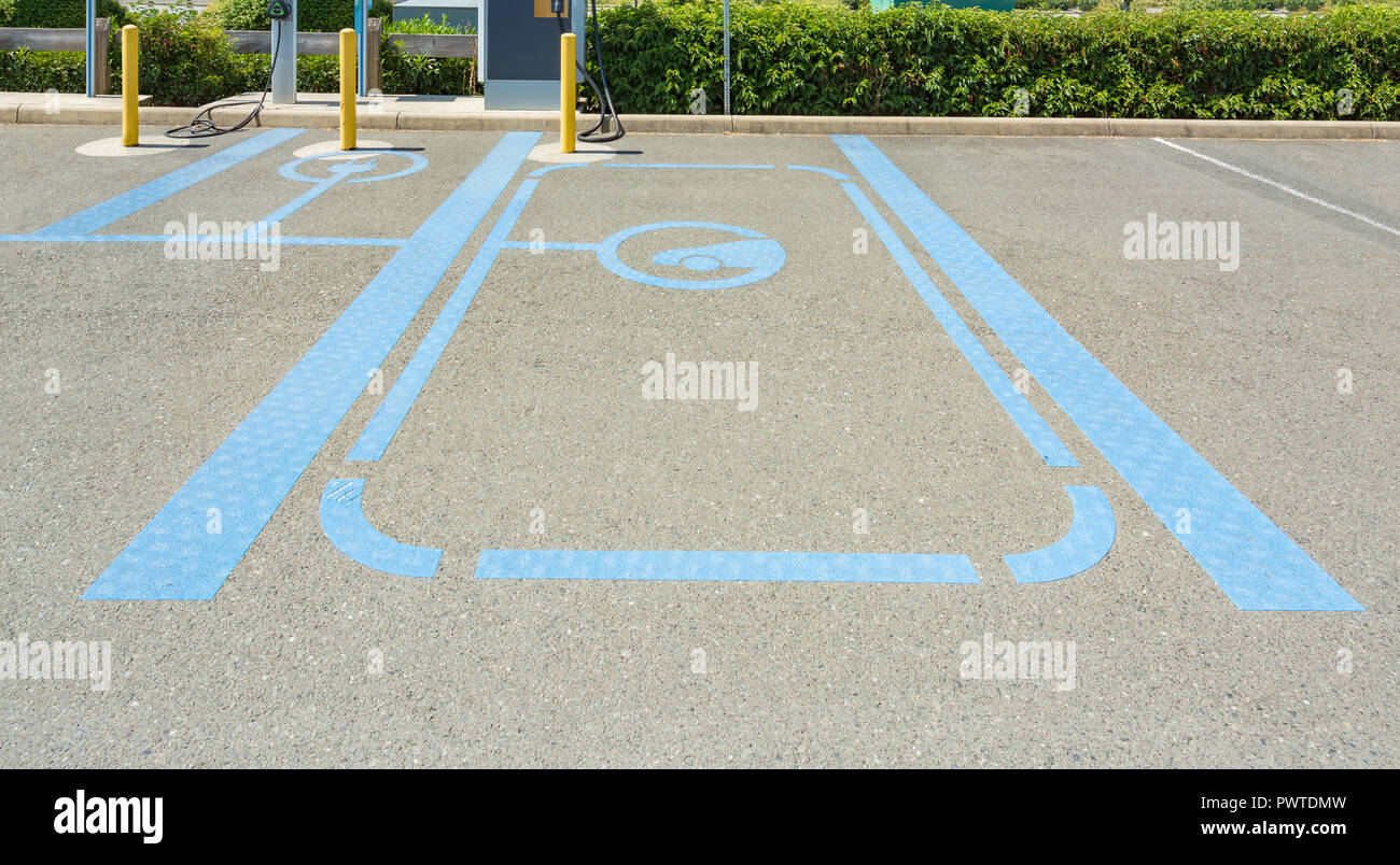 Parking spot with electric vehicle nearby charging stations Stock Photo
