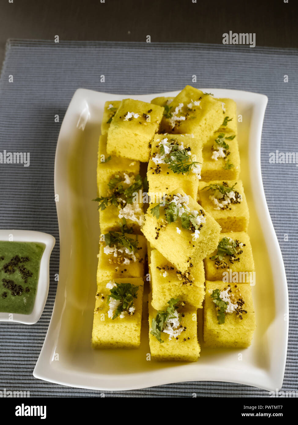 KHAMAN DHOKLA WITH CORIANDER CHUTNEY AND GREEN CHILLIES/ A STEAMED