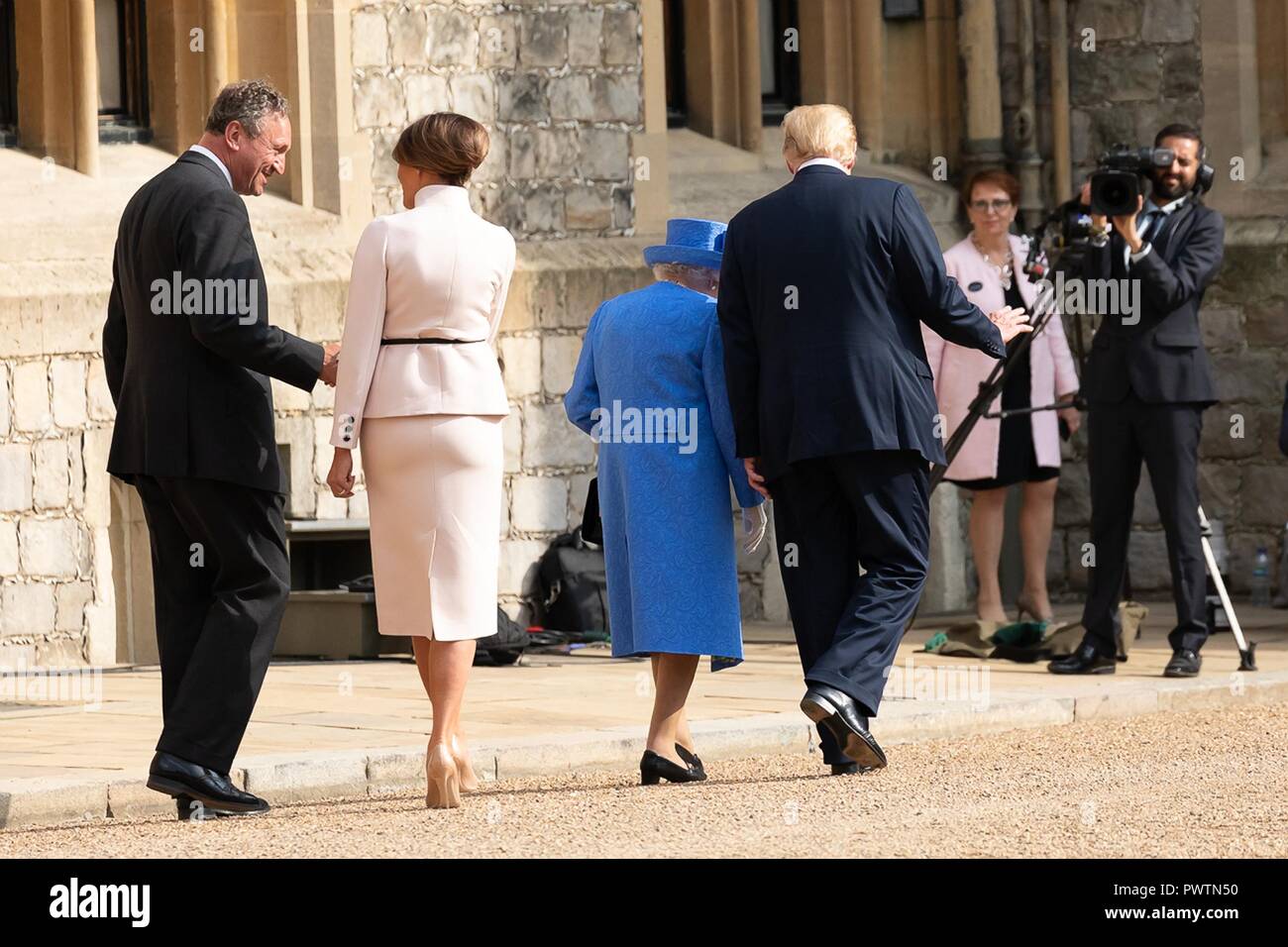 Her Majesty Queen Elizabeth II walks with U.S. President Donald Trump as First Lady Melania Trump follows behind at Windsor Castle July 13, 2018 in Windsor, United Kingdom. Stock Photo
