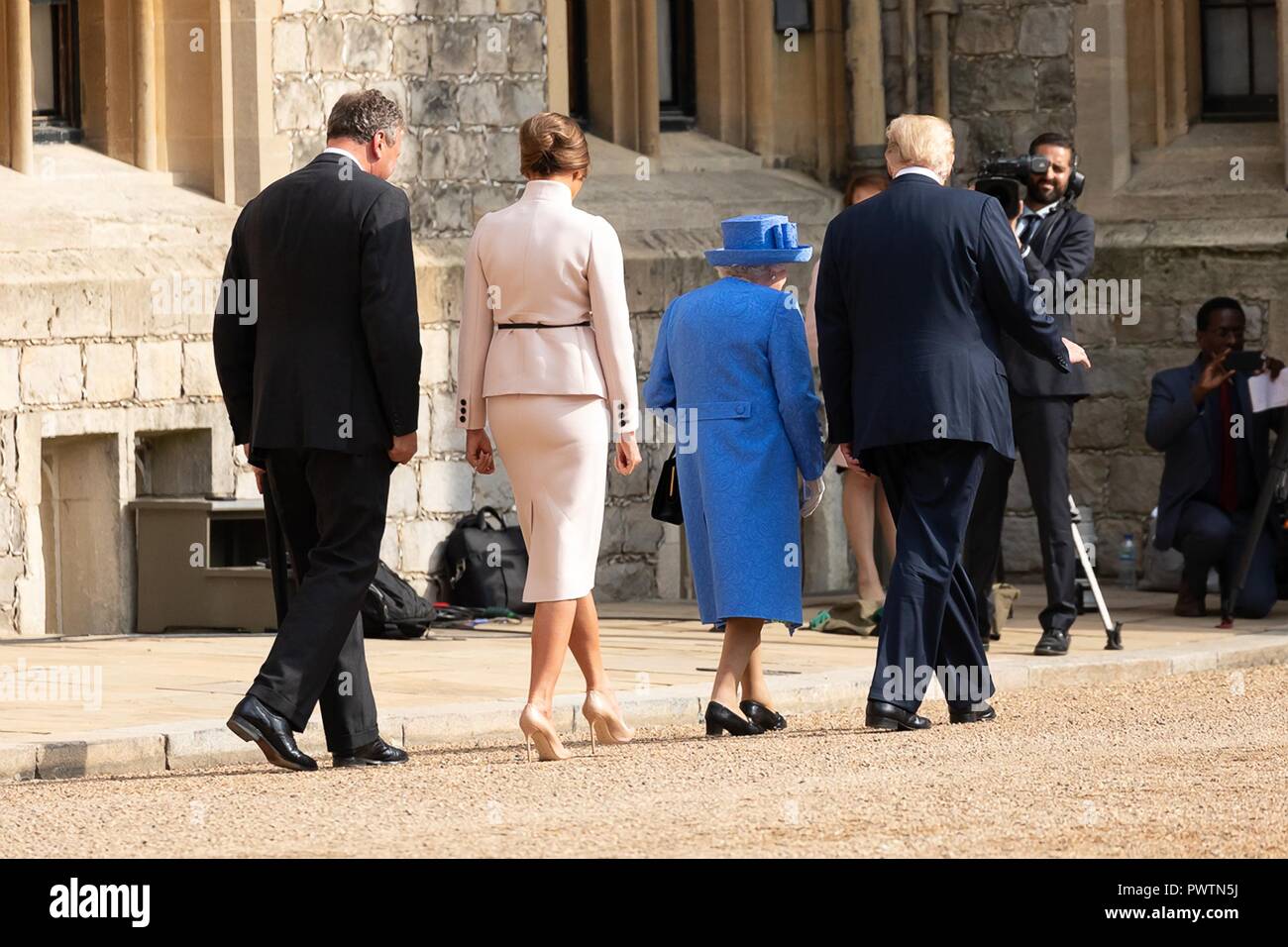 Her Majesty Queen Elizabeth II walks with U.S. President Donald Trump as First Lady Melania Trump follows behind at Windsor Castle July 13, 2018 in Windsor, United Kingdom. Stock Photo