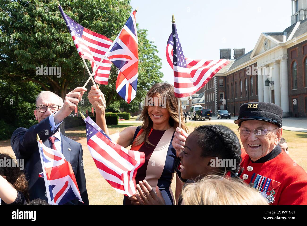 U.S First Lady Melania Trump and Philip May, husband of British Prime Minister Theresa May, wave British and American flags during a visit to the Royal Hospital Chelsea July 13, 2018 in London, United Kingdom. Stock Photo