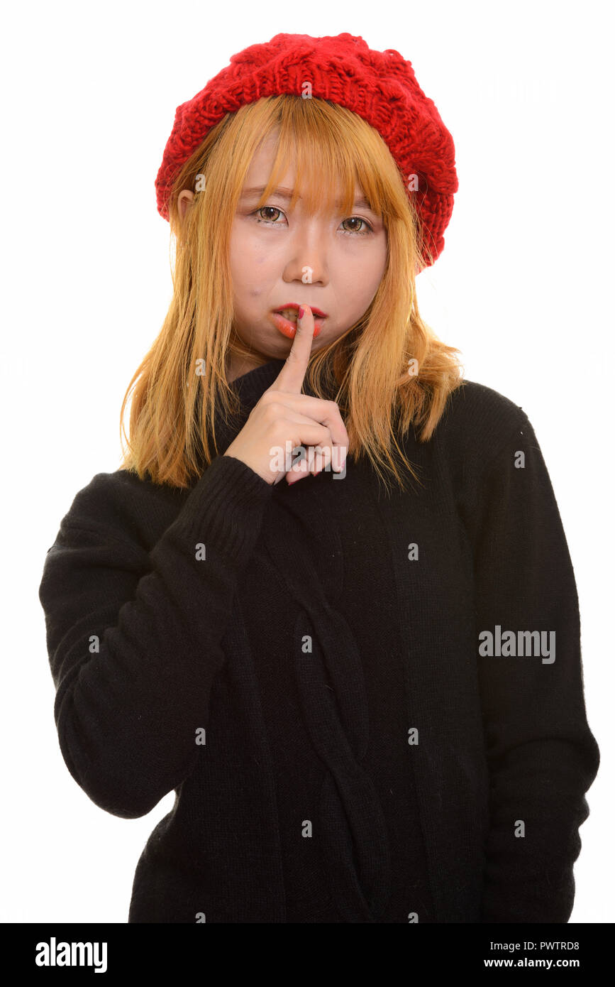 Young cute Asian woman with finger on lips Stock Photo