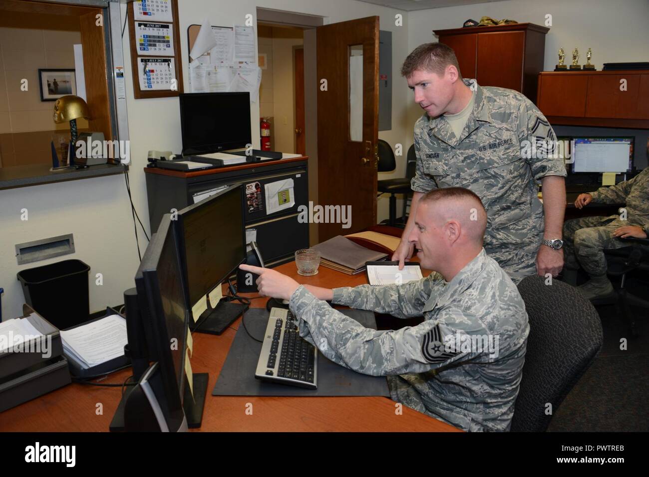 Senior Master Sgt. Joe Donovan 185th Air Refueling Wing Financial Management Superintendent, talks with Technical Sgt. Mike Winter 185th ARW Travel Pay Technician while at the Iowa Air National Guard’s 185th ARW Financial Management office in Sioux City, Iowa on June 21, 2017.  U.S. Air National Guard Stock Photo