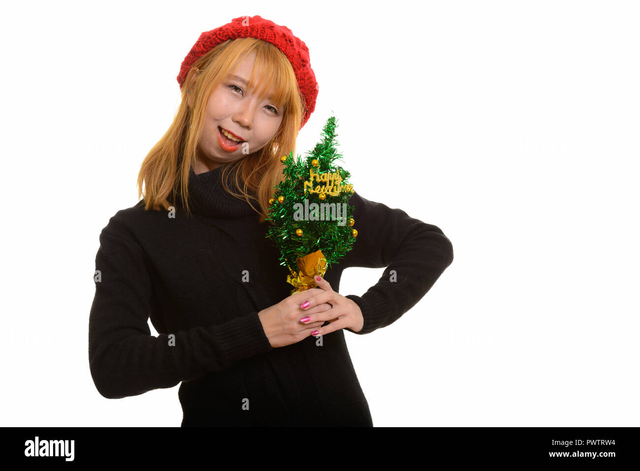 Cute happy Asian woman smiling while holding Happy New Year tree Stock Photo