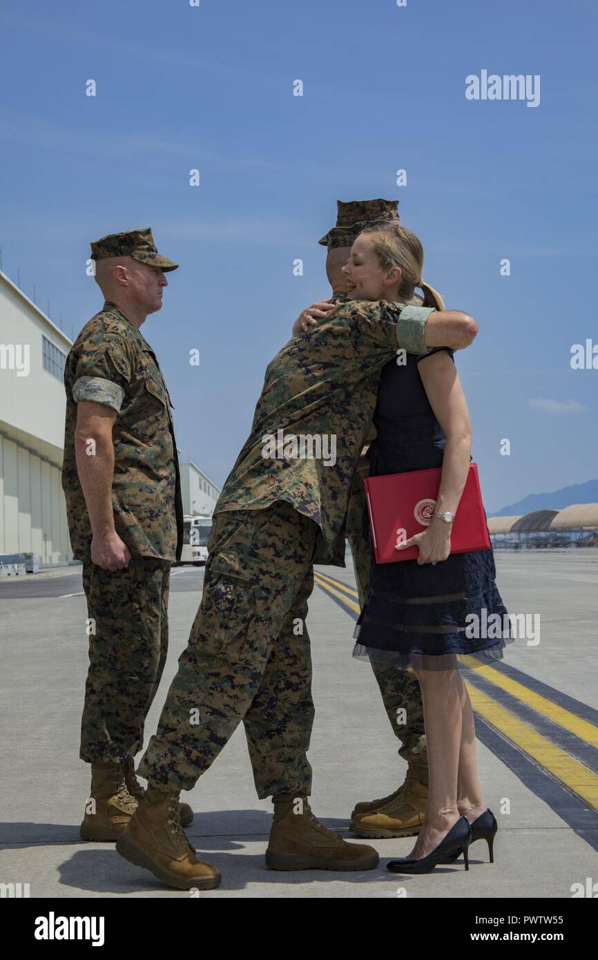 U.S. Marine Corps Maj. Gen. Russell A. Sanborn, left, the commanding general of 1st Marine Aircraft Wing, III Marine Expeditionary Force, hugs Mrs. Kimberly Shipley, right, wife of former Marine Aircraft Group (MAG) 12 commanding officer, after an award presentation, during a change of command ceremony at Marine Corps Air Station Iwakuni, Japan, June 23, 2017. After two years of dedicated service to MAG-12, U.S. Marine Corps Col. Daniel Shipley was relieved of his duties to continue on and serve in Washington D.C. at Headquarters Marine Corps with Programs and Resources. Stock Photo