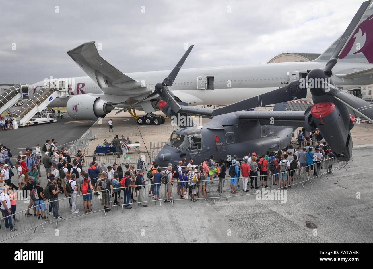 Air show attendees wait in line to tour a CV-22 Osprey from Royal Air Force Mildenhall, England, at Le Bourget Airport, France, during the Paris Air Show, June 23, 2017. The Paris Air Show offers the U.S. a unique opportunity to showcase their leadership in aerospace technology to an international audience. By participating, the U.S. hopes to promote standardization and interoperability of equipment with their NATO allies and international partners. This year marks the 52nd Paris Air Show and the event features more than 100 aircraft from around the world. Stock Photo