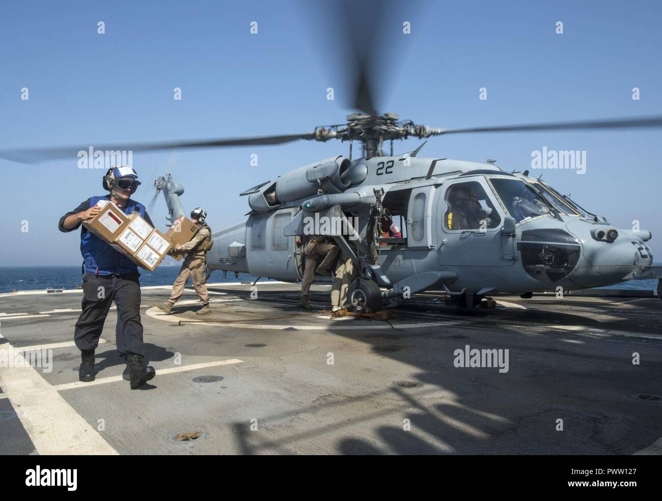 ARABIAN GULF (June 19, 2017) Sailors assigned to the guided-missile cruiser USS Vella Gulf (CG 72) unload mail and supplies from an MH-60S Sea Hawk helicopter, assigned to the Desert Hawks of Helicopter Sea Combat (HSC) Squadron 26, during Exercise Spartan Kopis 17.  Exercise Spartan Kopis is a Task Force (TF) 55-led exercise between the U.S. Navy and U.S. Coast Guard in order to increase tactical proficiency, broaden levels of cooperation, enhance mutual capability and support long-term security and stability in the region. Vella Gulf is deployed to the U.S. 5th Fleet area of operations to re Stock Photo
