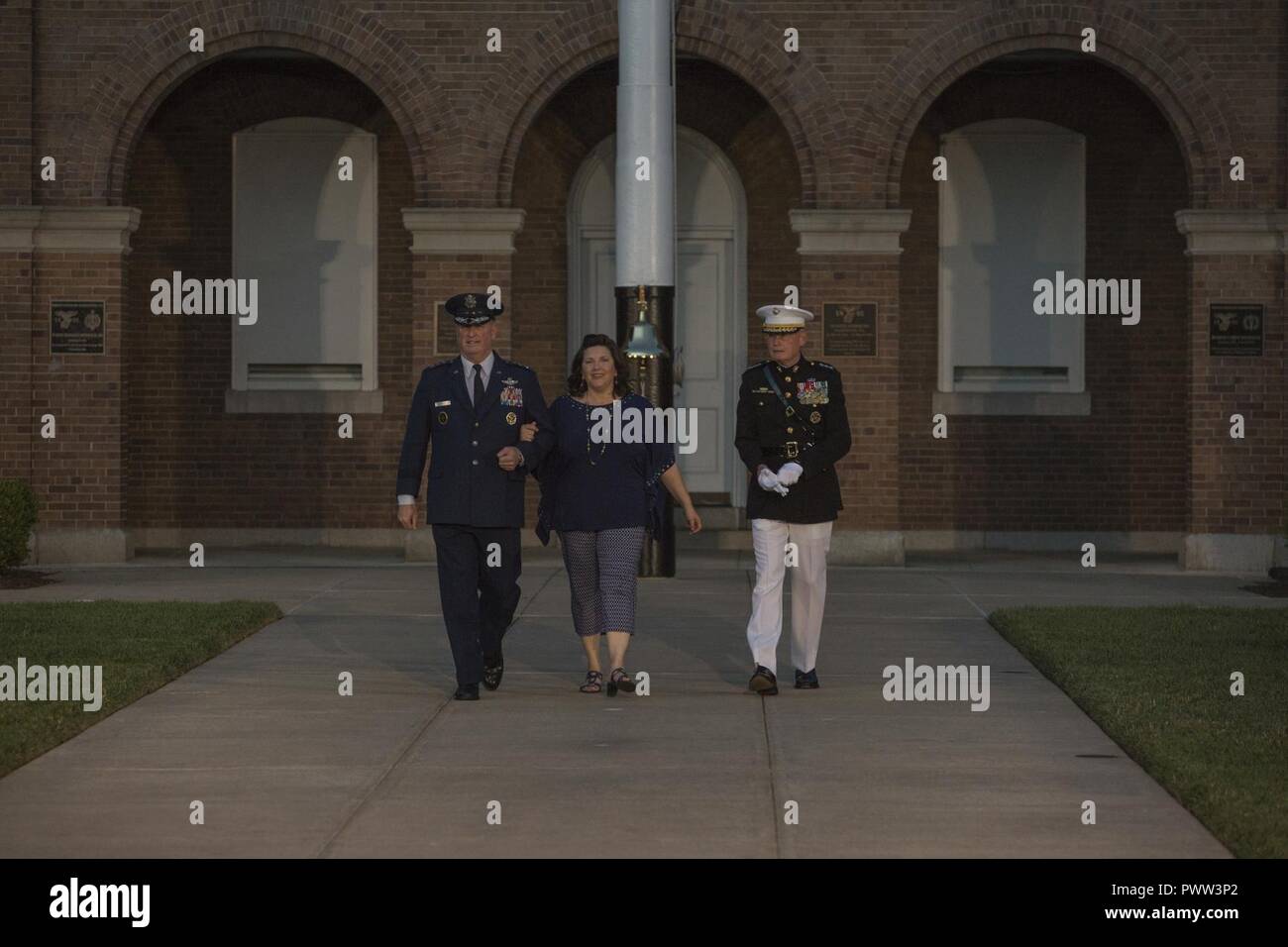 U.S. Air Force Lt. Gen. Thomas J. Trask, vice commander of Headquarters U.S. Special Operations Command (SOCOM), left, Barbara Trask, center, and Director Marine Corps Staff Lt. Gen. James B. Laster, right, walk down centerwalk prior to an evening parade at Marine Barracks Washington, Washington, D.C., June 23, 2017. Evening parades are held as a means of honoring senior officials, distinguished citizens and supporters of the Marine Corps. Stock Photo