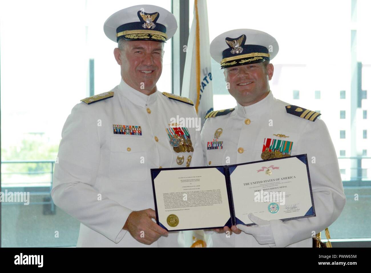 Coast Guard Vice Adm. Karl L. Schultz and Cmdr. Justin M. Carter hold a ...