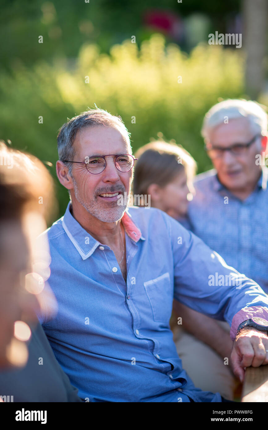 Family picnic. Focus on a handsome grey hair man  Stock Photo