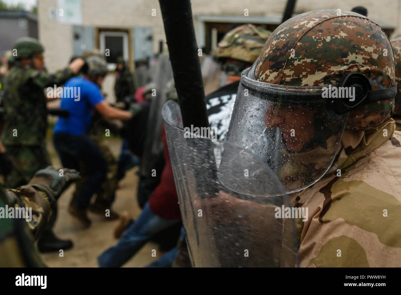 An Armenian soldier of Armenian Infantry Company prepares for contact while conducting a crowd riot control scenario during a Kosovo Force (KFOR) mission rehearsal exercise (MRE) at the Joint Multinational Readiness Center in Hohenfels, Germany, June 29, 2017. The KFOR MRE 23 is designed to prepare the 39th Infantry Brigade Combat Team for their deployment to Kosovo in support of civil authorities to maintain a safe and secure environment. KFOR MRE 23 hosts 900 soldiers from 10 nations. The exercise runs from June 19 through July 11 in Hohenfels, Germany. Stock Photo