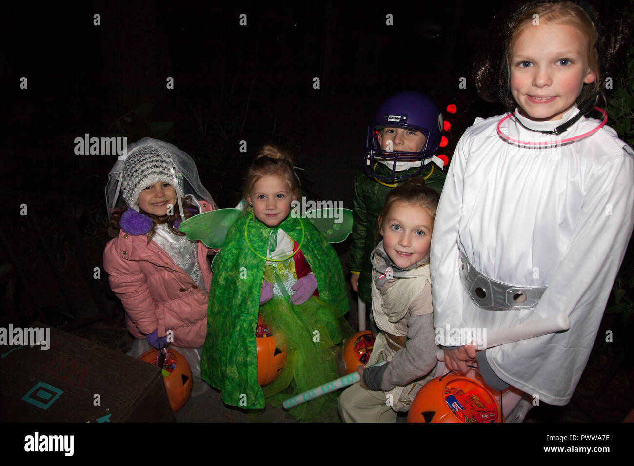 Group of young Halloween trick or treaters costumed as Princess Leia, fairy, Jedi Knight & football player. St Paul Minnesota MN USA Stock Photo