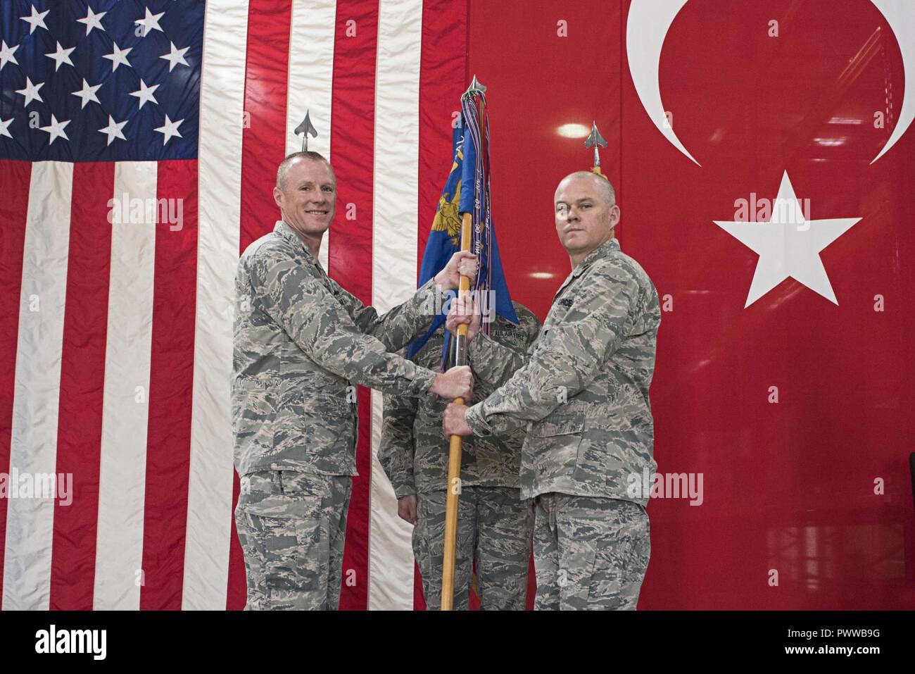 U.S. Air Force Col. Todd Stratton, 39th Mission Support Group commander, passes the guidon to Maj. Matthew Shaw, incoming 39th Logistics Readiness Squadron commander June 29, 2017, at Incirlik Air Base, Turkey. Stratton presided over the change of command. Stock Photo