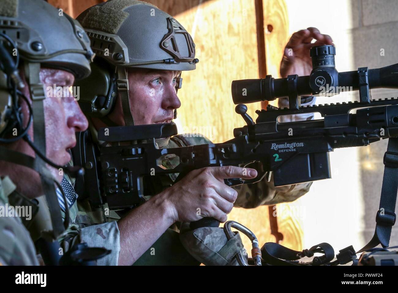 A U.S. paratrooper scans for targets behind a Barrett .50-caliber sniper  rifle while on a