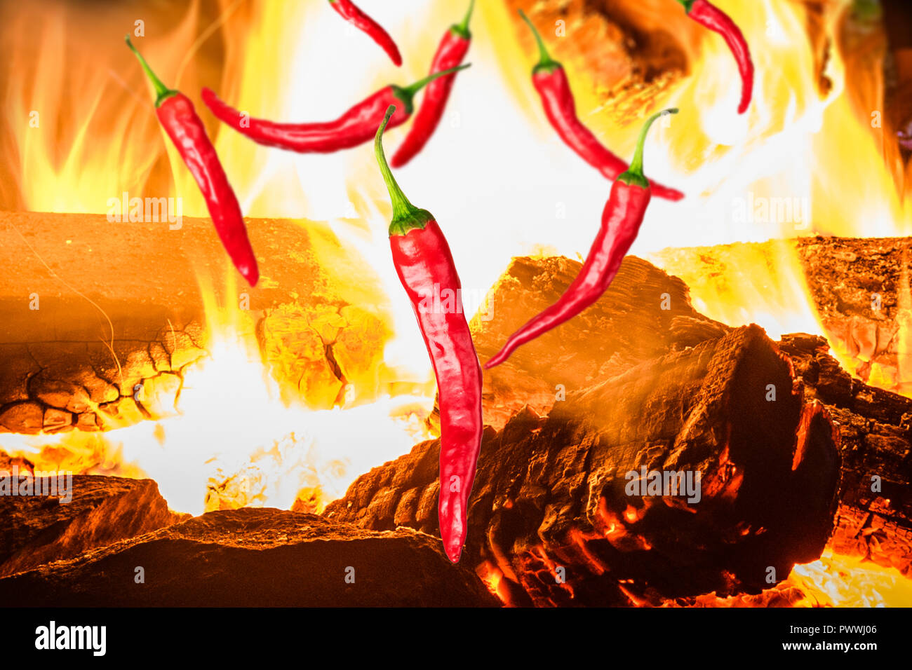 a few pieces of red chili peppers on background with fire Stock Photo