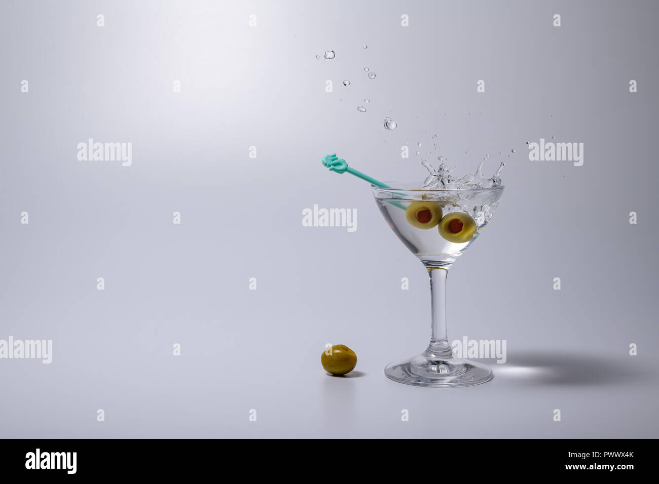 Splashing Martini cocktail liquor drink with the pickled olive Stock