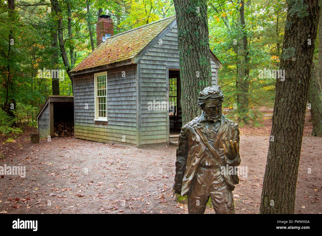 Concord, MA--Oct 11, 2018; statue of the American writer Henry David Thoreau in front of recreation of the house he lived in at Walden Pond Stock Photo