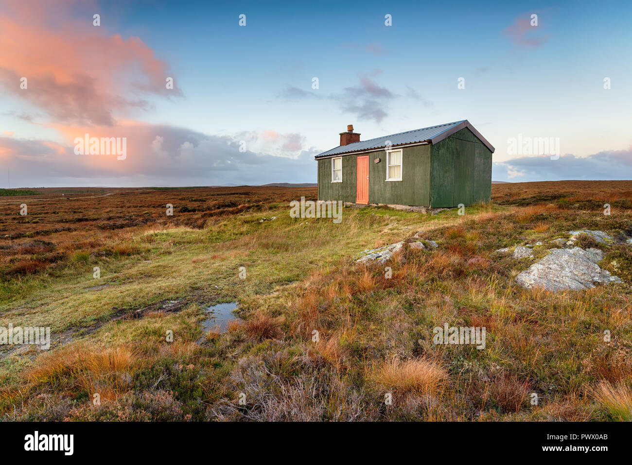 A tiny cottage or hut known as a shieling which is used for shelter while pasturing animals, on peat bog near Stornoway on the Isle of Lewis in Scotla Stock Photo