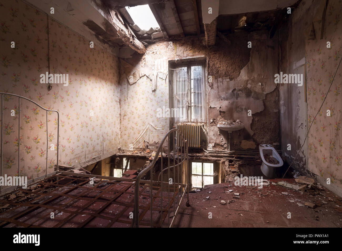 Interior view of a room with hole in ceiling and floor in an abandoned