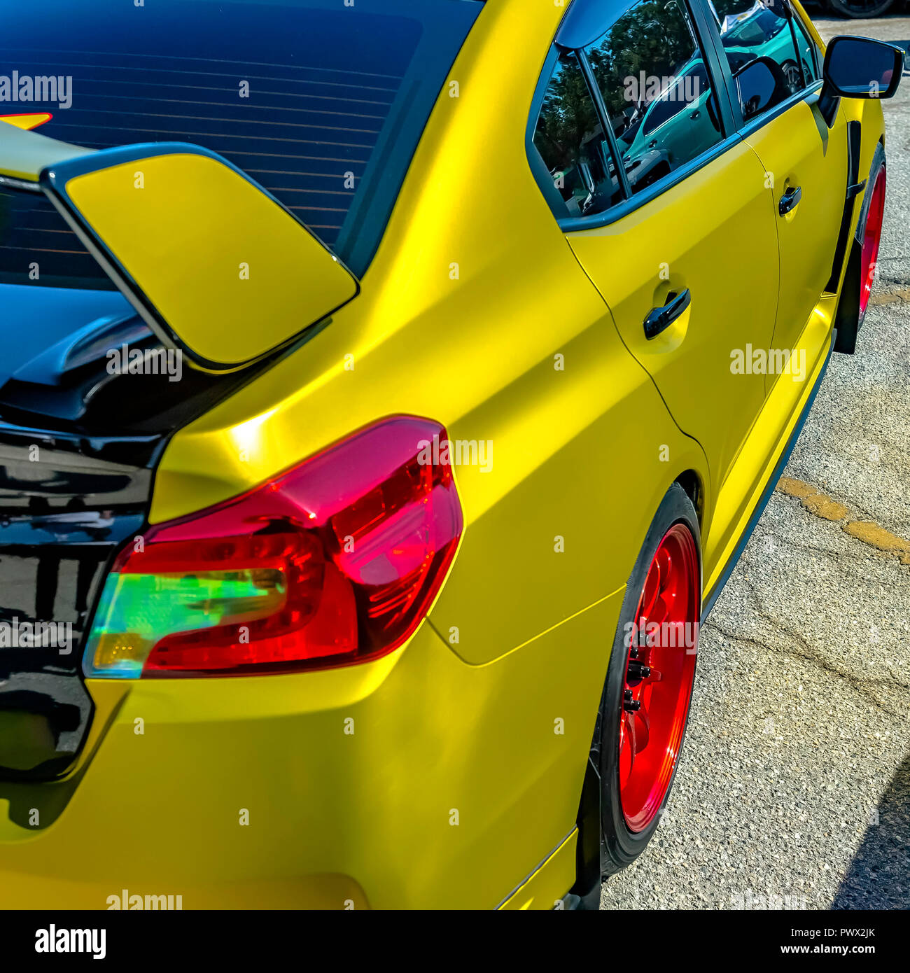 Metallic yellow car with bright red wheel rim Stock Photo Alamy