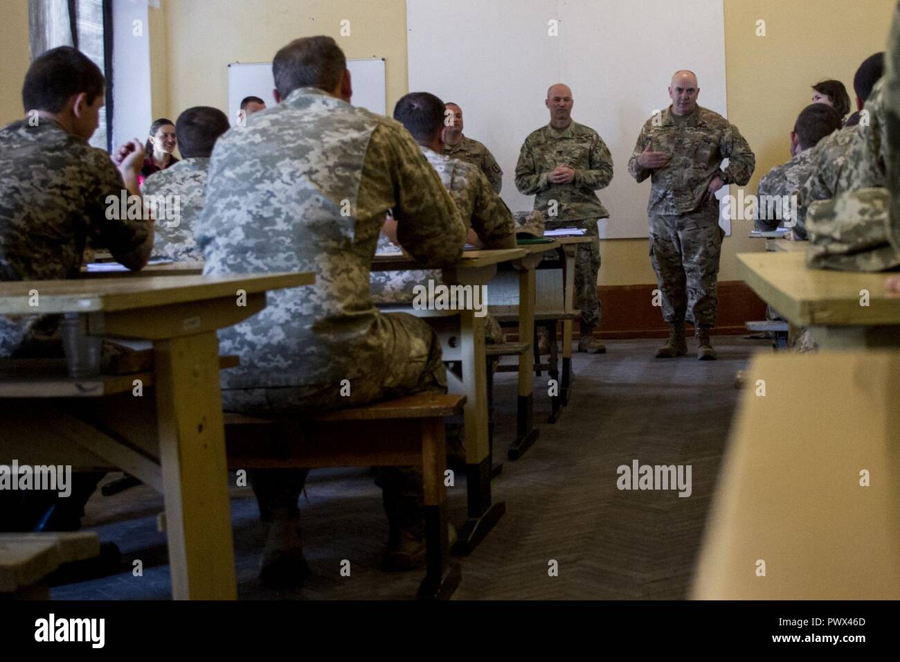 Col. David Jordan and Command Sgt. Major Christopher Miller, the command team for the Joint Multinational Training Group-Ukraine and the 45th Infantry Brigade Combat Team, speak to Ukrainian sergeants studying at the 197th Noncommissioned Officer Training Center in Desna, Ukraine on July 6.    The 45th is deployed to Ukraine as part of the JMTG-U, an international coalition dedicated to building professionalism of the Ukrainian army. Strengthening the Ukrainian army's NCO corps is a primary goal of the JMTG-U mission. Stock Photo