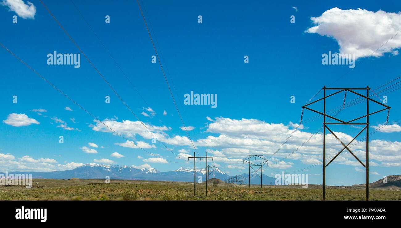 Power lines with view of mountain under blue sky Stock Photo - Alamy