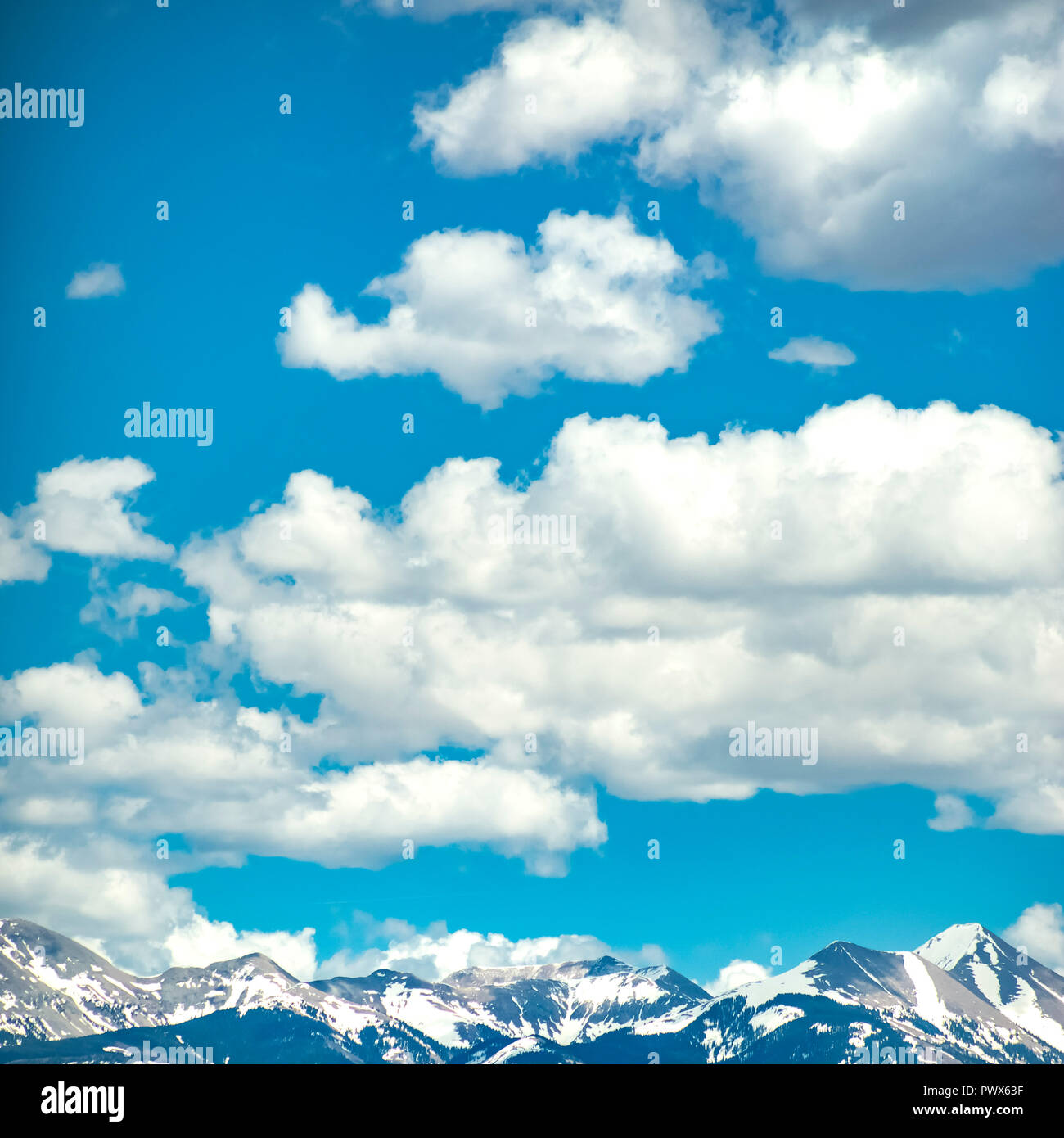 Snow capped mountain under blue sky and clouds Stock Photo - Alamy