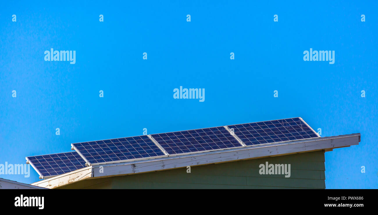 Solar panels on a roof against blue sky Stock Photo - Alamy