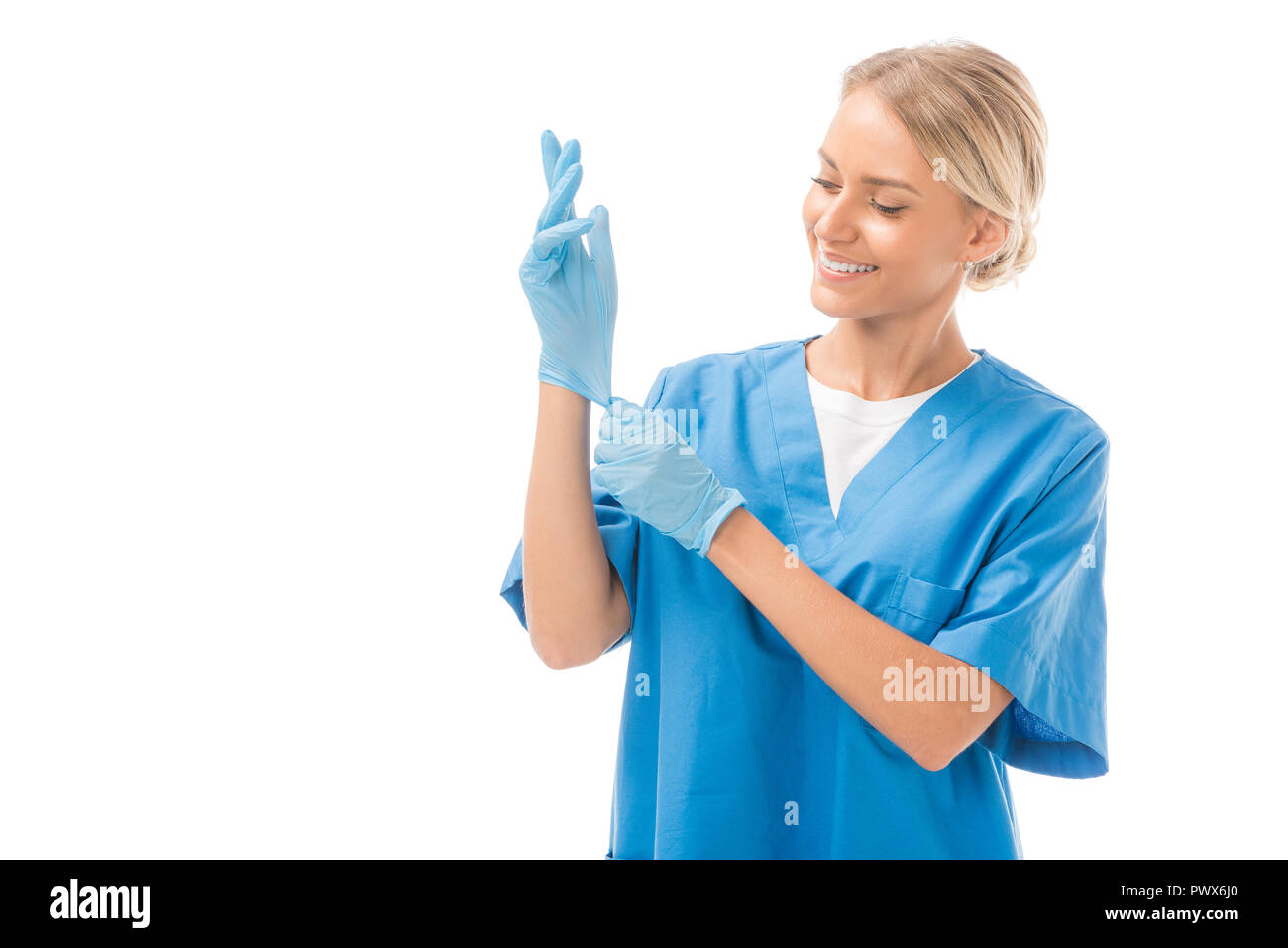beautiful young nurse putting on rubber gloves isolated on white Stock