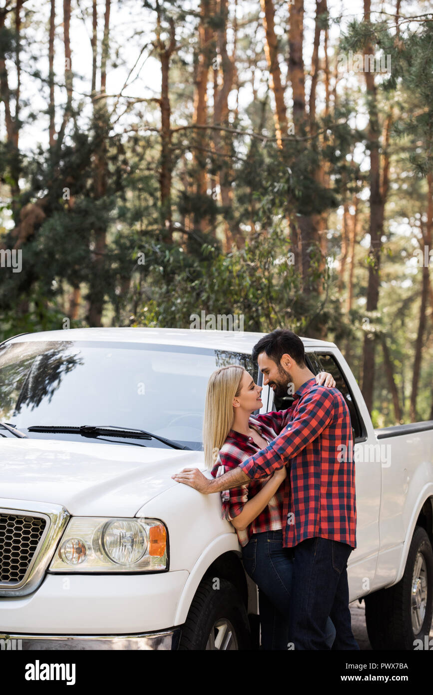 beautiful couple going to kiss near pickup truck in forest Stock Photo