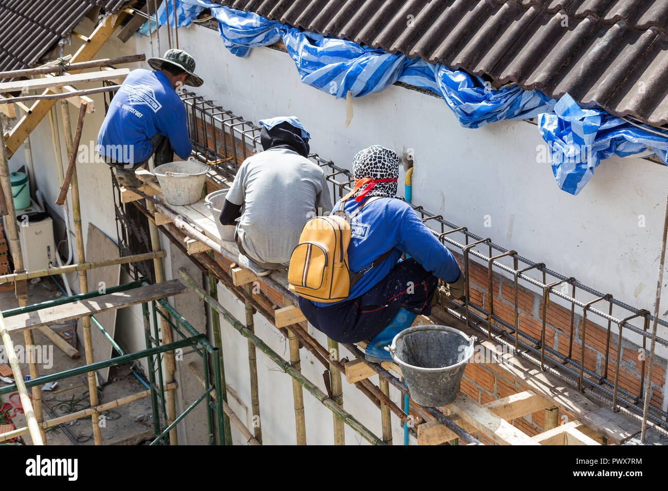 CHIANG MAI, THAILAND - 13 August 2018 - Male and female construction workers prepare rebar steels for concrete beams and colunms and a house construct Stock Photo