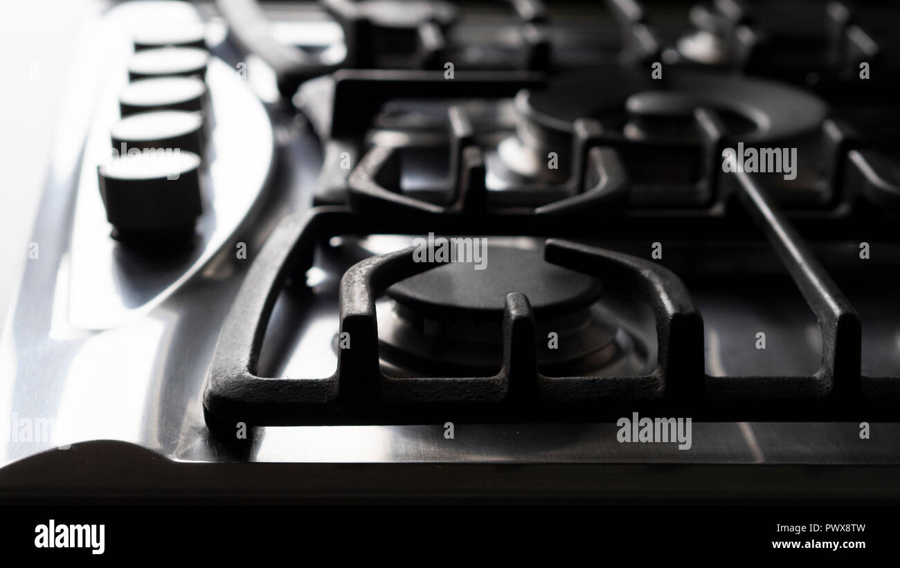 Steel and cast iron parts of modern gas cooker; large clean kitchen