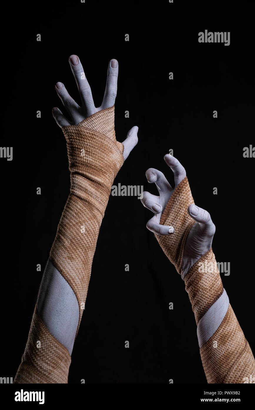 Spooky mummy stretching up hands wrapped in bandages, Halloween Stock Photo
