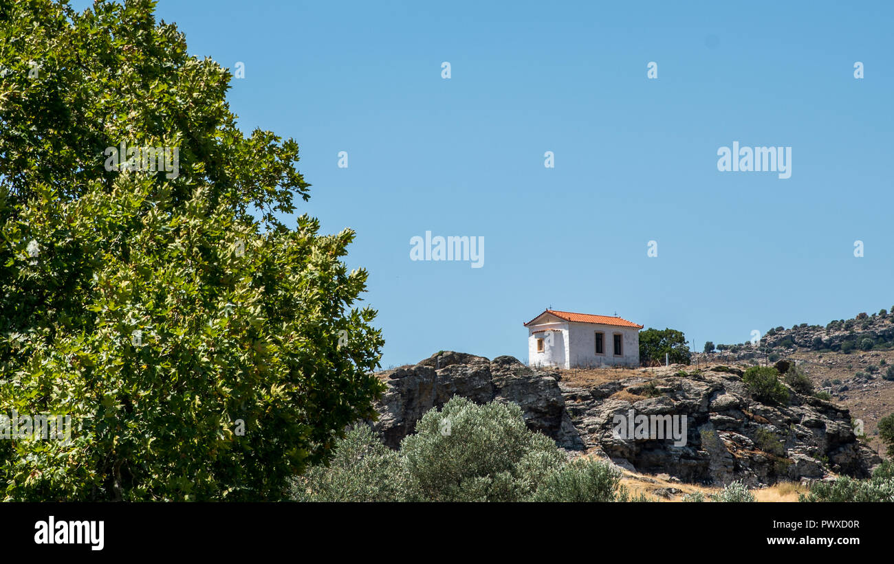 Small Greek Orthodox church on a rocky hill Stock Photo