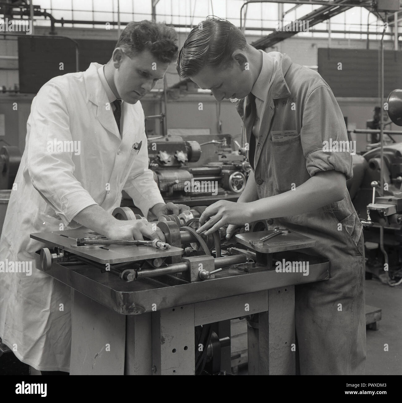 1962, aviation, apprentice, picture shows an experienced white-coated male engineer helping a young male apprentice with a machine tool, England, UK. Stock Photo