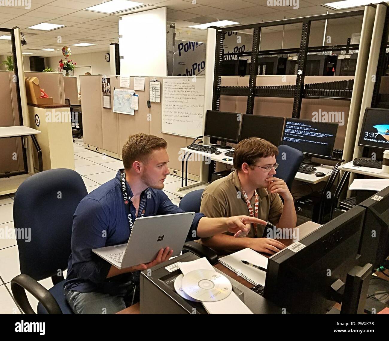 Joe Scanlan, a premier field engineer with Microsoft, and Mike Foldes, an information technology support specialist with Navy Personnel Command, troubleshoot simultaneous application deployment in Memphis, Tennessee, June 22, 2017. Scanlan, a former U.S. Marine Corps sergeant and combat correspondent, visits commercial companies and military bases across the U.S. to teach their IT staff about a systems management product that can upgrade thousands of machines simultaneously, provide active reporting on security patching across all machines, deploy software updates and install applications on a Stock Photo