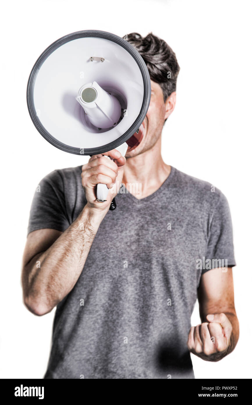 young man holding a megaphone in protest attitude Stock Photo