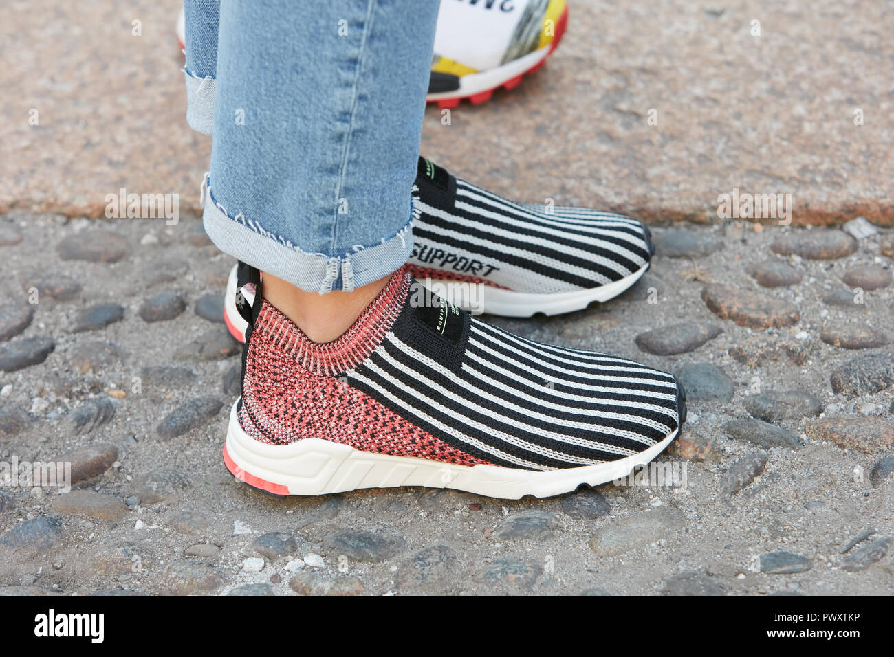 MILAN, ITALY - SEPTEMBER 21, 2018: Woman with striped Adidas sneakers and  blue denim trousers before Tods fashion show, Milan Fashion Week street  styl Stock Photo - Alamy