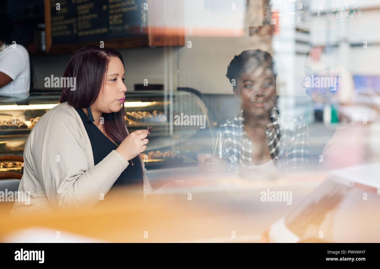 Diverse young friends talking together inside of a cafe Stock Photo