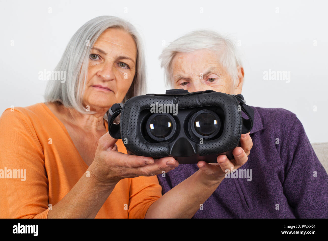 Elderly women experiencing virtual reality video with headset Stock