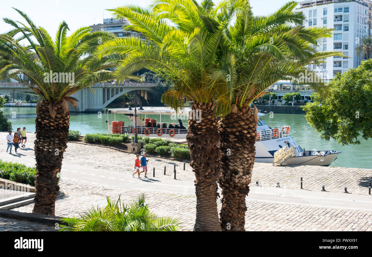 People walking along the bank of the River Guadalquivir in Seville, Spain Stock Photo