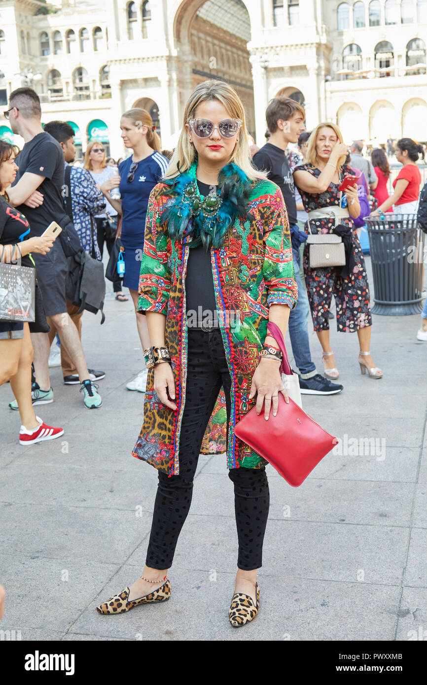 MILAN, ITALY - SEPTEMBER 21, 2018: Woman with green feathers necklace and colorful jacket before Calcaterra fashion show, Milan Fashion Week street st Stock Photo