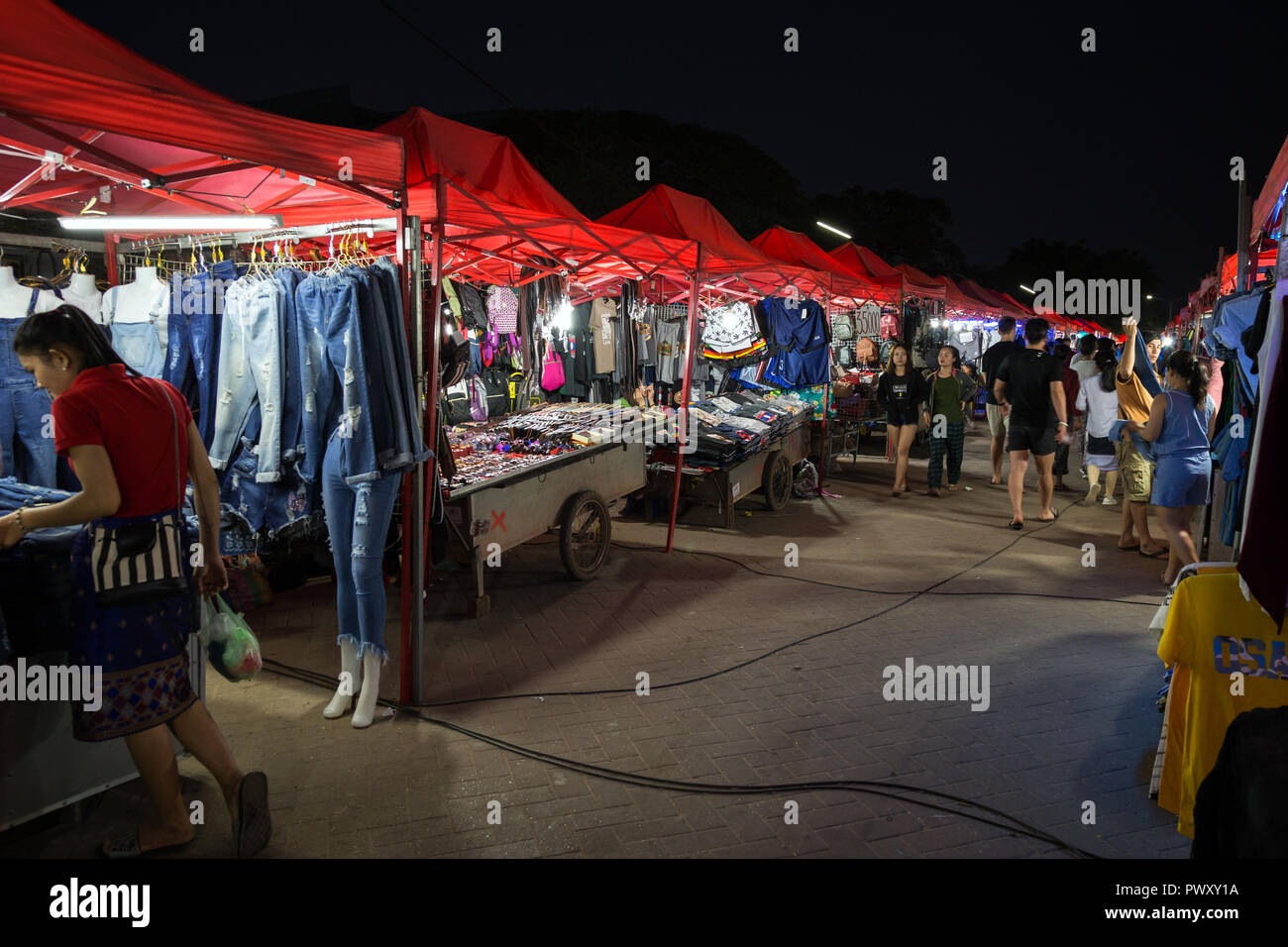 Many stalls full of clothes and other merchandise, local people and tourists at famous and popular Riverside Night Market in Vientiane, Laos, at night Stock Photo