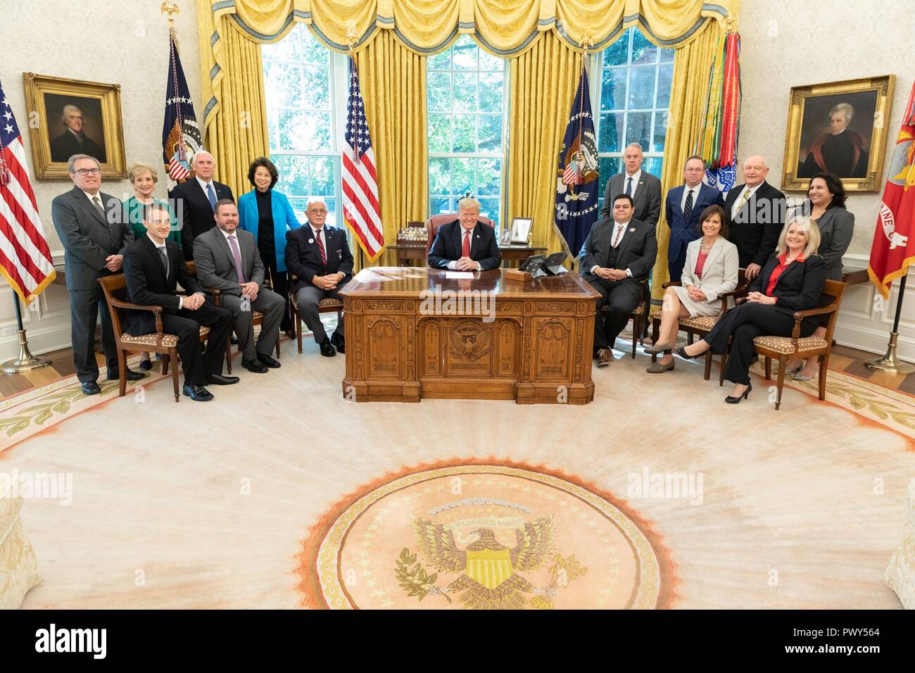 U.S President Donald Trump, joined by Vice President Mike Pence and members of his Cabinet pose for a group photo after the “Cutting the Red Tape and Unleashing Economic Freedom” event in the Oval Office of the White House October 17, 2018 in Washington, DC. Stock Photo
